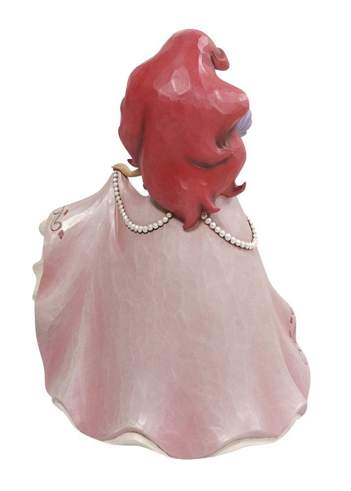 Een beeldje van Ariel in een roze jurk, met een hoed in haar hand en rood haar.
