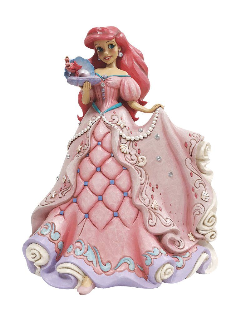 Een beeldje van Ariel in een roze jurk, met een hoed in haar hand en rood haar.
