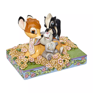 Een Bambi-figuurtje met Stampertje en Bloem op een doos met bloemen- en bladmotieven.