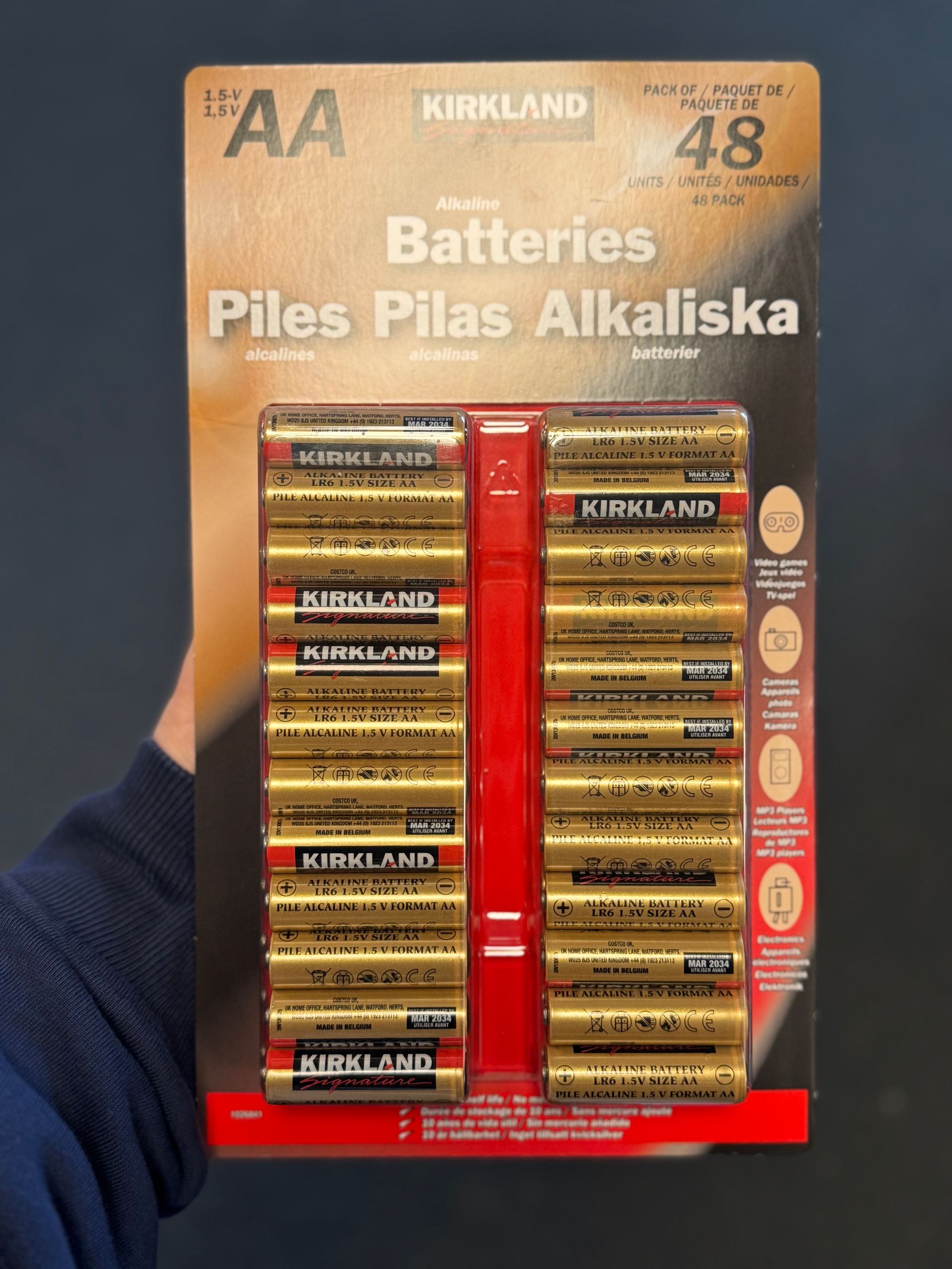 Verpakking Kirkland AA alkalinebatterijen; goud en rood op een kartonnen achterkant. 48 stuks.