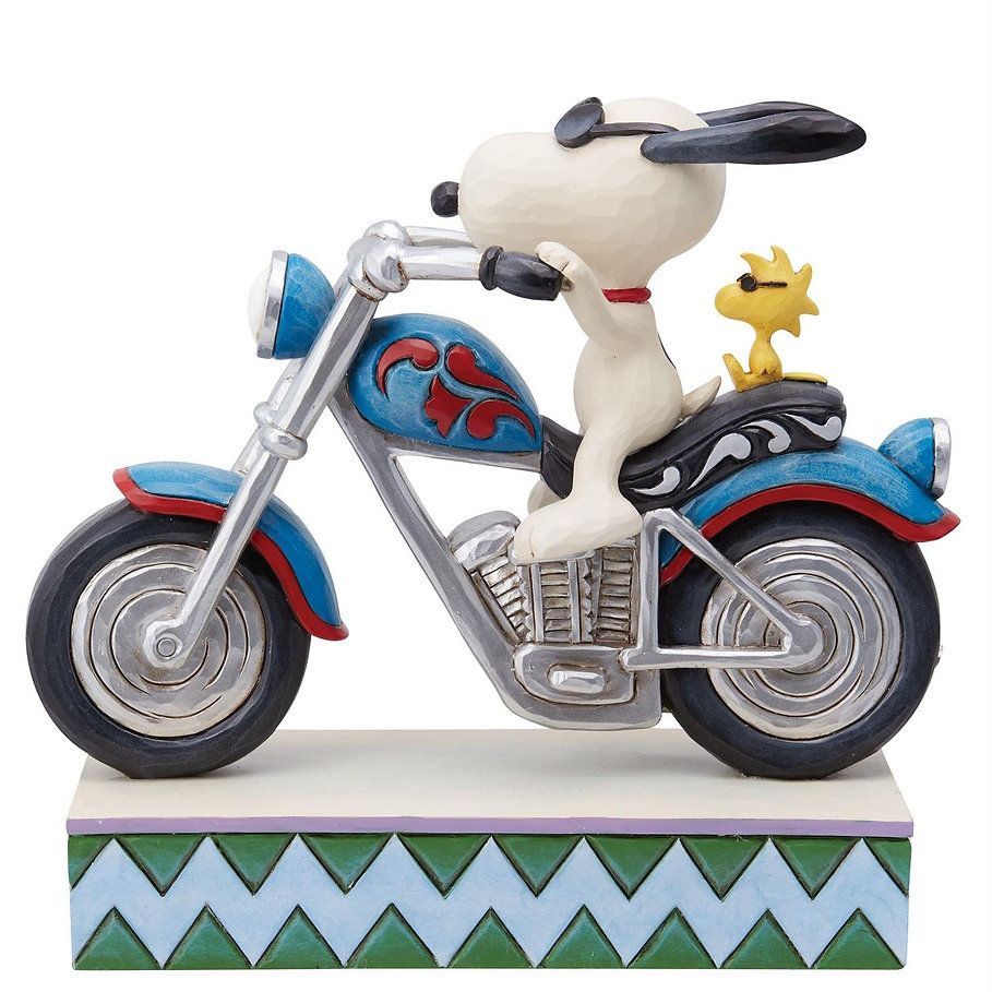 Snoopy en Woodstock op een blauwe motor met decoratieve vlammen, lachend, op een sokkel met een zigzagrand.