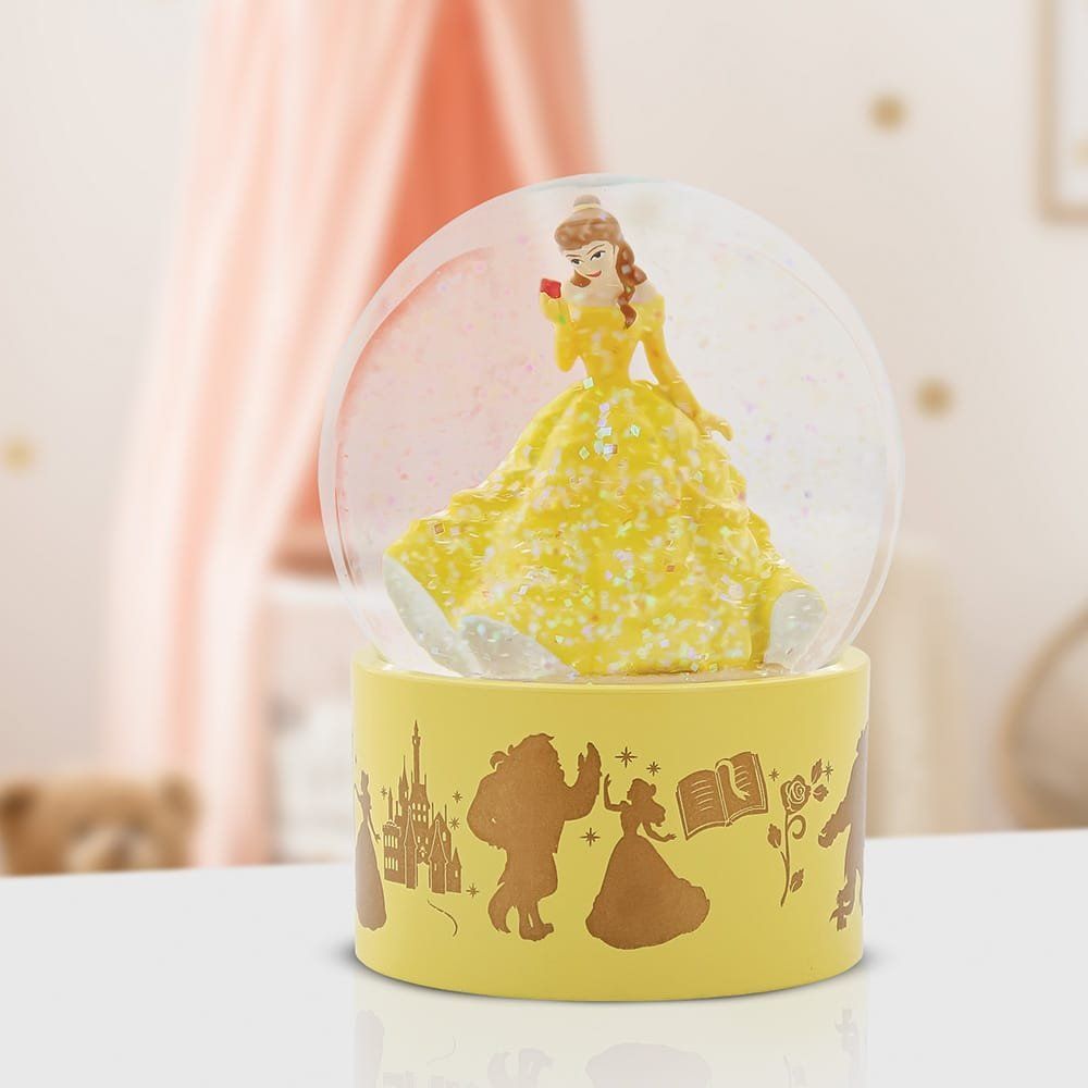 Sneeuwbol met Belle in een gele jurk, die een roos vasthoudt, op een gele voet met silhouetten van het Beest.