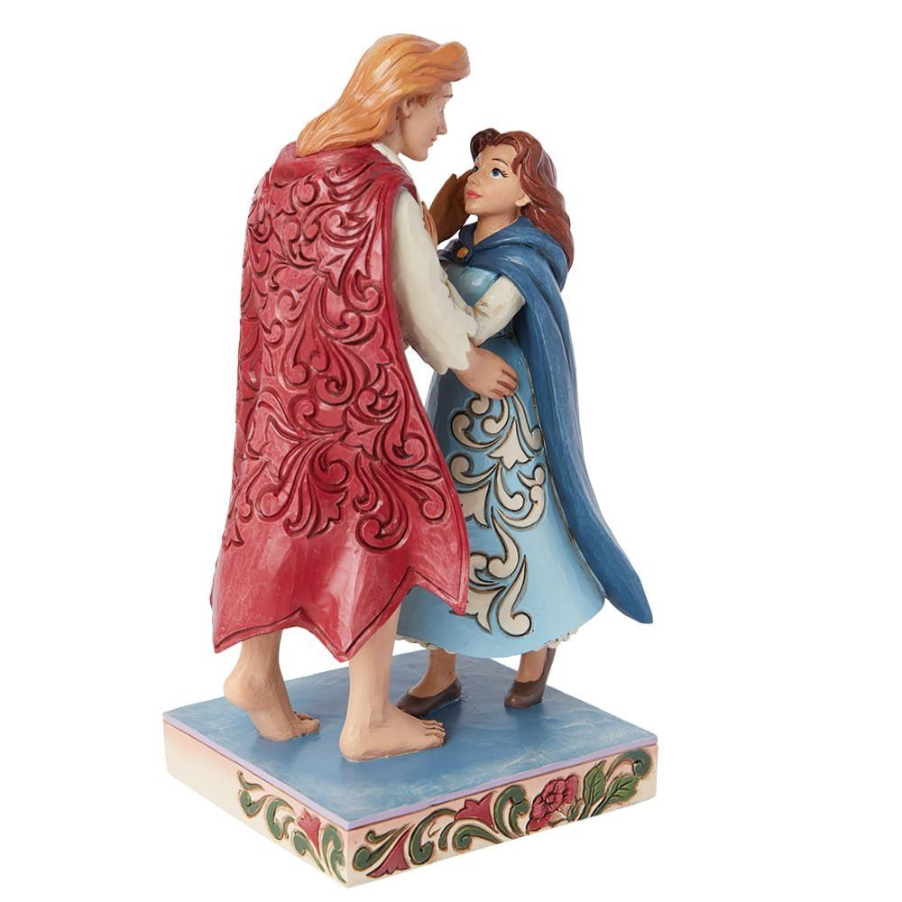 Beeldje van een dansend paar. Man in rode cape, vrouw in blauwe jurk. Ze kijken elkaar aan. Op een versierde sokkel.