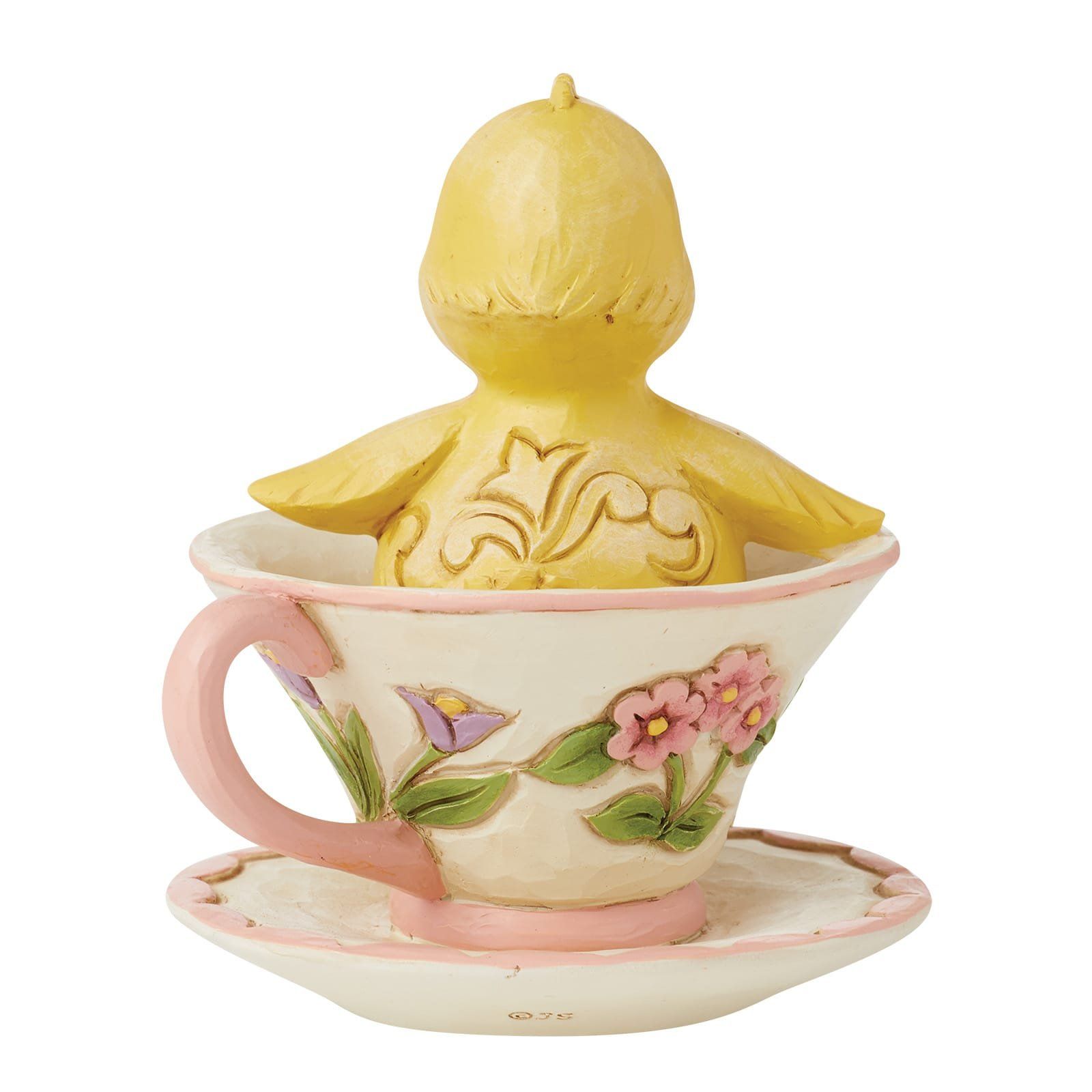 Geel vogeltje dat uit een met bloemen versierd theekopje op schoteltje tevoorschijn komt; roze accenten.