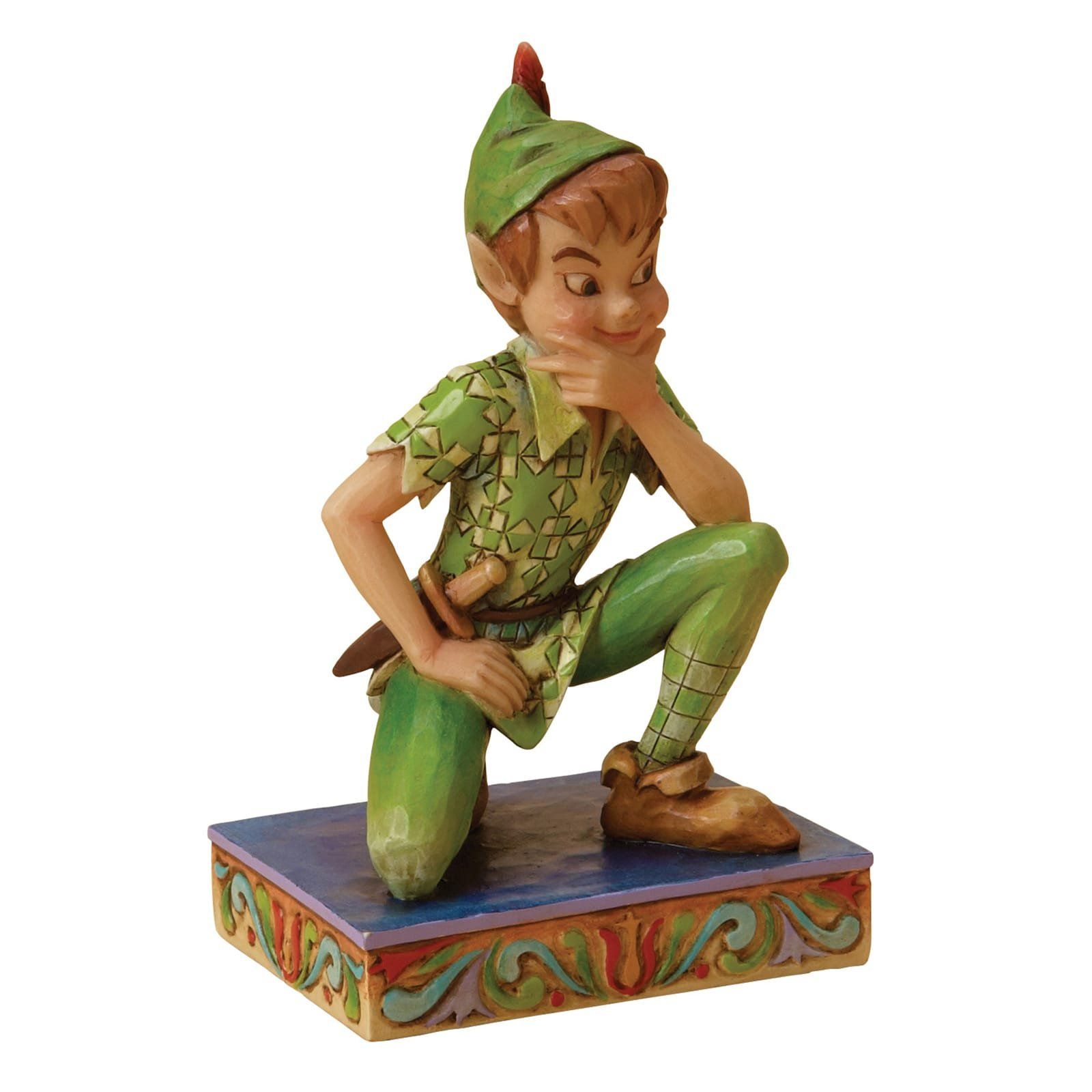 Een Peter Pan-beeldje, knielend met zijn hand aan zijn kin, op een versierde sokkel, gekleed in een groen pak.