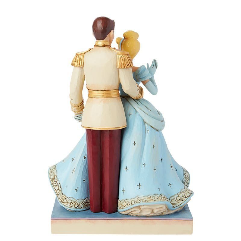 Een beeldje van Assepoester en Prins Charmant, gekleed in blauw en goud, die elkaar omarmen.