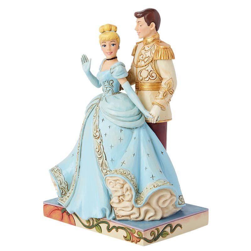 Disney's Assepoester-beeldje, in een lichtblauwe jurk, zwaaiend, de prins houdt haar hand vast, op een bloemvormige sokkel.