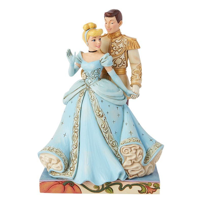 Een beeldje van Assepoester en Prins Charmant, gekleed in blauw en goud, die elkaar omarmen.