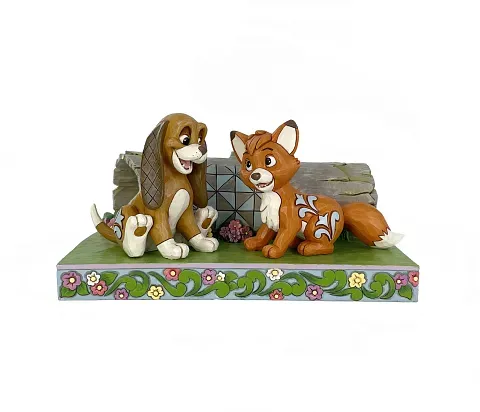 Standbeeld van Tod de vos en Copper de hond die samen zitten en glimlachen.
