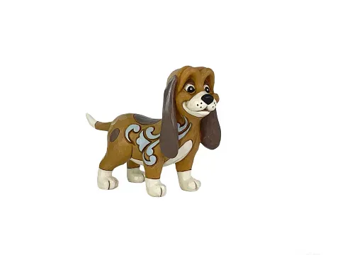 Cartoonhondje, bruin en wit, met lange oren, lachend, versierd met blauwe krullen.