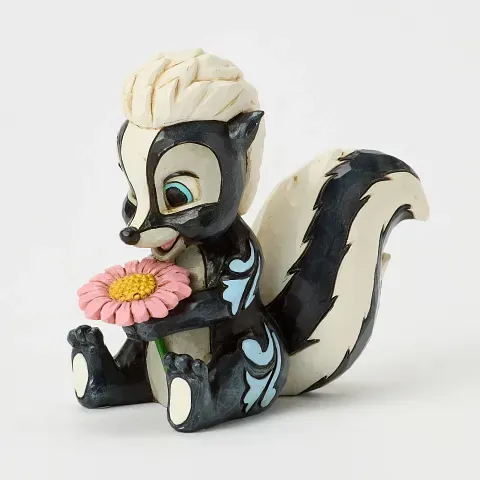 Speels stinkdierfiguurtje met een roze bloem, in zwart, wit en blauw.