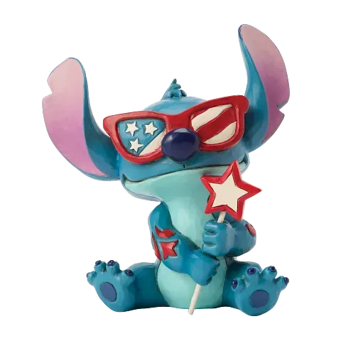 Een Stitch-figuurtje met een zonnebril in de vorm van een vlag en een toverstaf met een ster in zijn hand.