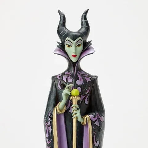 Een beeldje van Maleficent, in een zwart-paarse jurk, met een groene huid, en een staf met een gele bol.