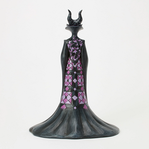 Een beeldje van Maleficent, met een groene bol in haar hand, gekleed in zwarte en paarse gewaden en met hoorns, tegen een witte achtergrond.