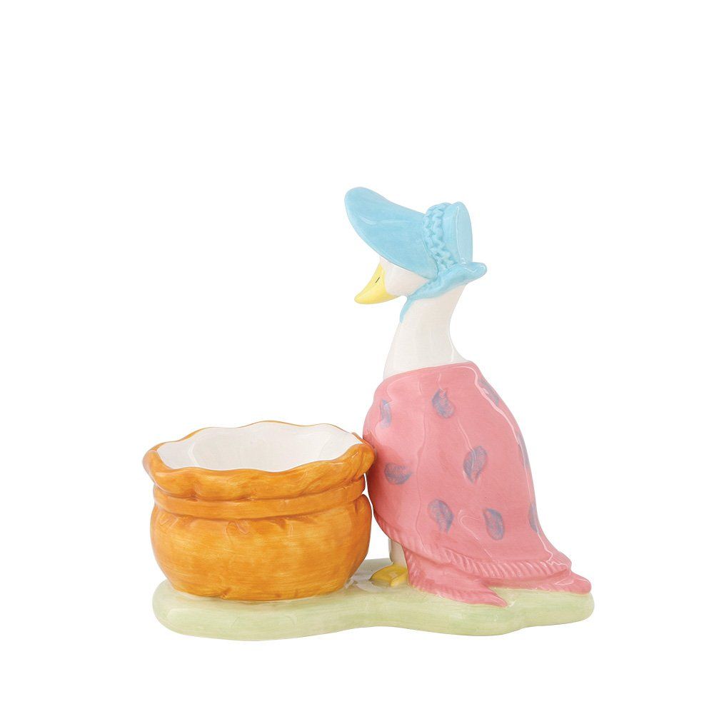 Een eendje met een blauw mutsje en een roze sjaal, naast een mandje.