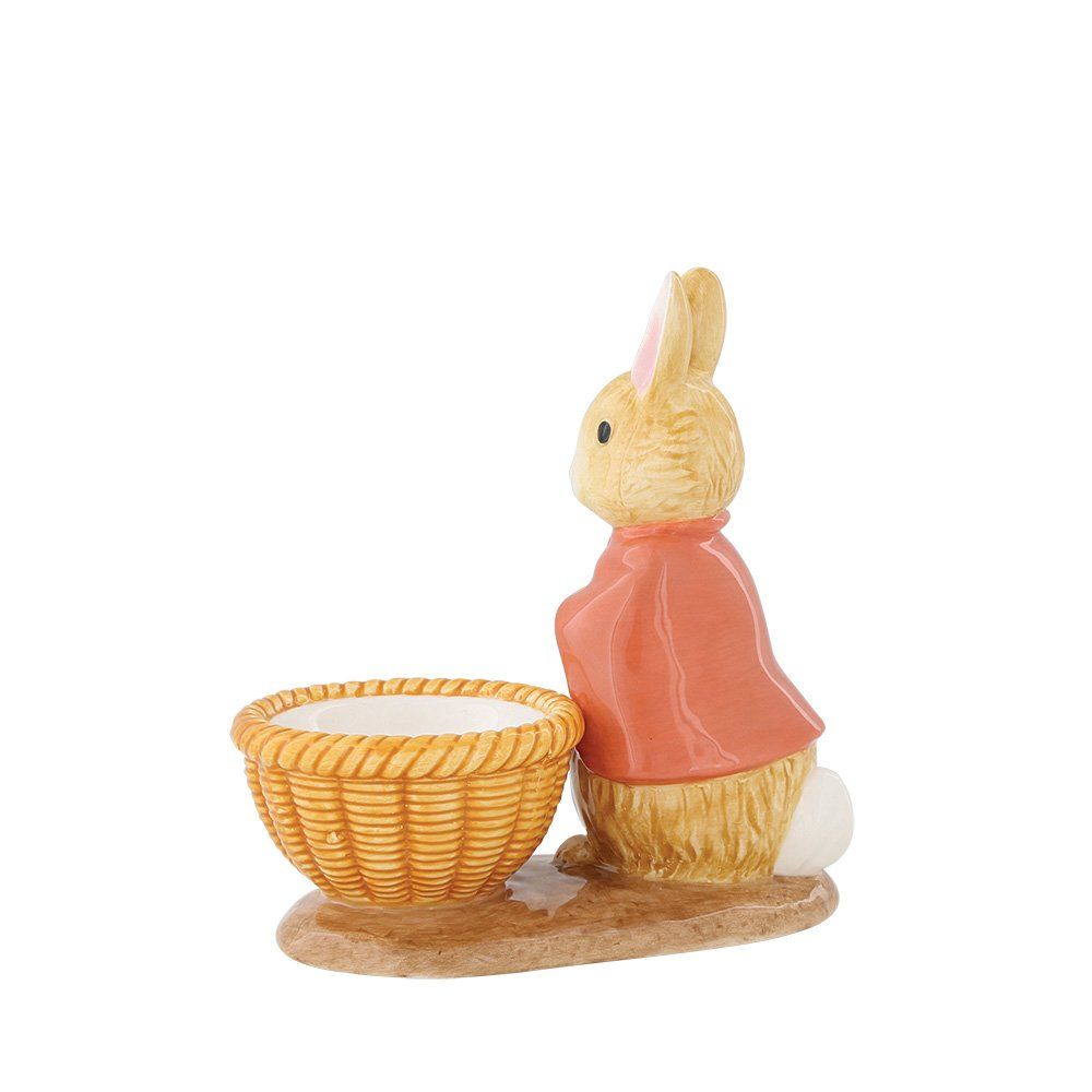 Peter Rabbit-figuurtje met een mandje. Het konijn draagt een rode cape en staat naast een gevlochten mandje.