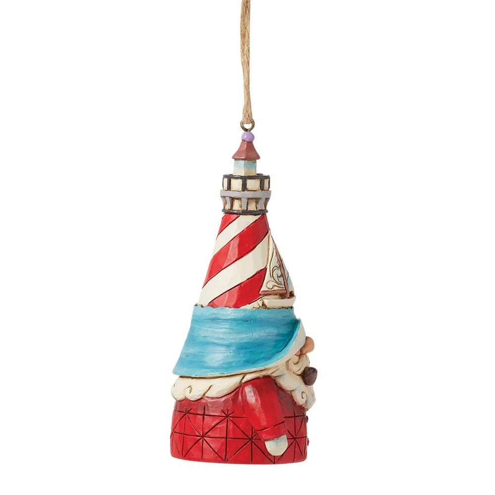 Ornament van een vuurtorenkabouter met een rood-wit gestreepte toren, een blauwe sjaal en een rode jas, opgehangen aan een touwtje.
