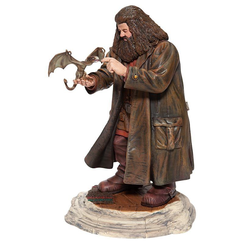 Standbeeld van Hagrid uit Harry Potter, met een babydraakje in zijn armen en gekleed in een lange bruine jas.