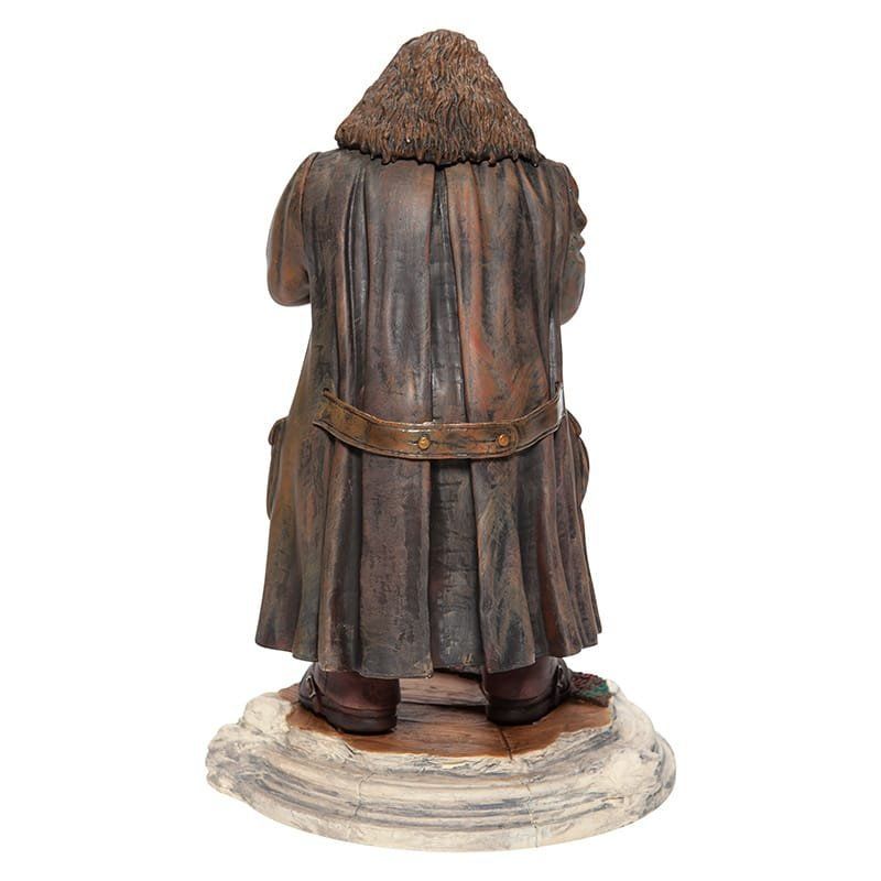 Standbeeld van Hagrid, van achteren gezien, gekleed in een bruine jas en staand op een sokkel.
