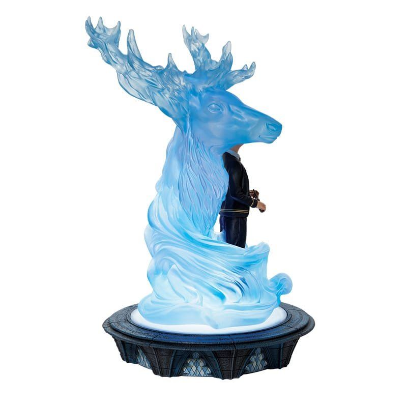 Standbeeld van een hertenpatronus met een figuur erin, verlicht met blauw licht, op een decoratieve sokkel.