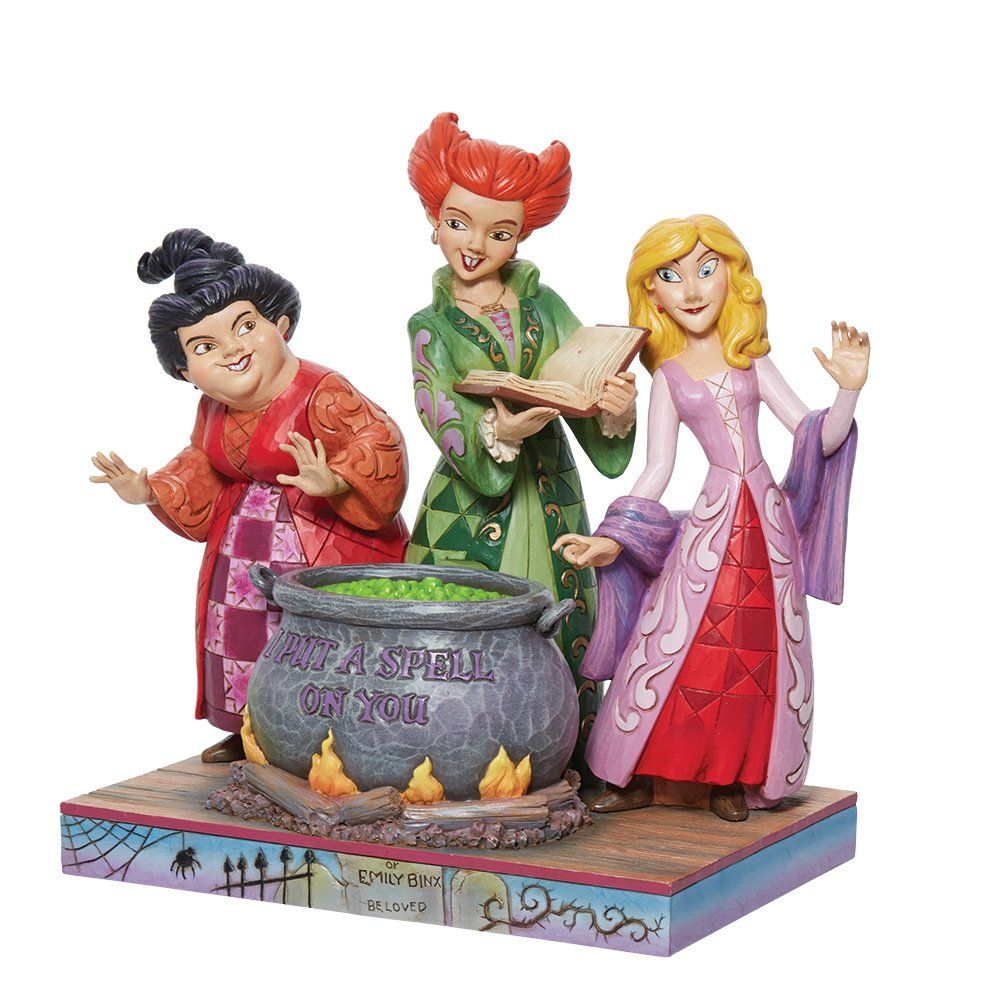 Standbeeld van de Sanderson-zussen uit Hocus Pocus rond een ketel met vuur, op een sokkel.