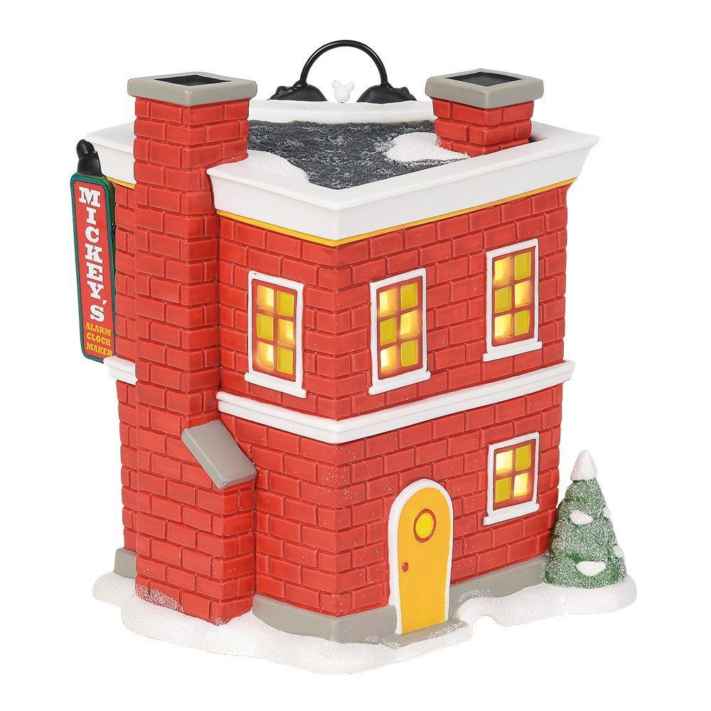 Disney-kerstdorp: een rood bakstenen gebouw met een klok, Mickey Mouse en sneeuw.