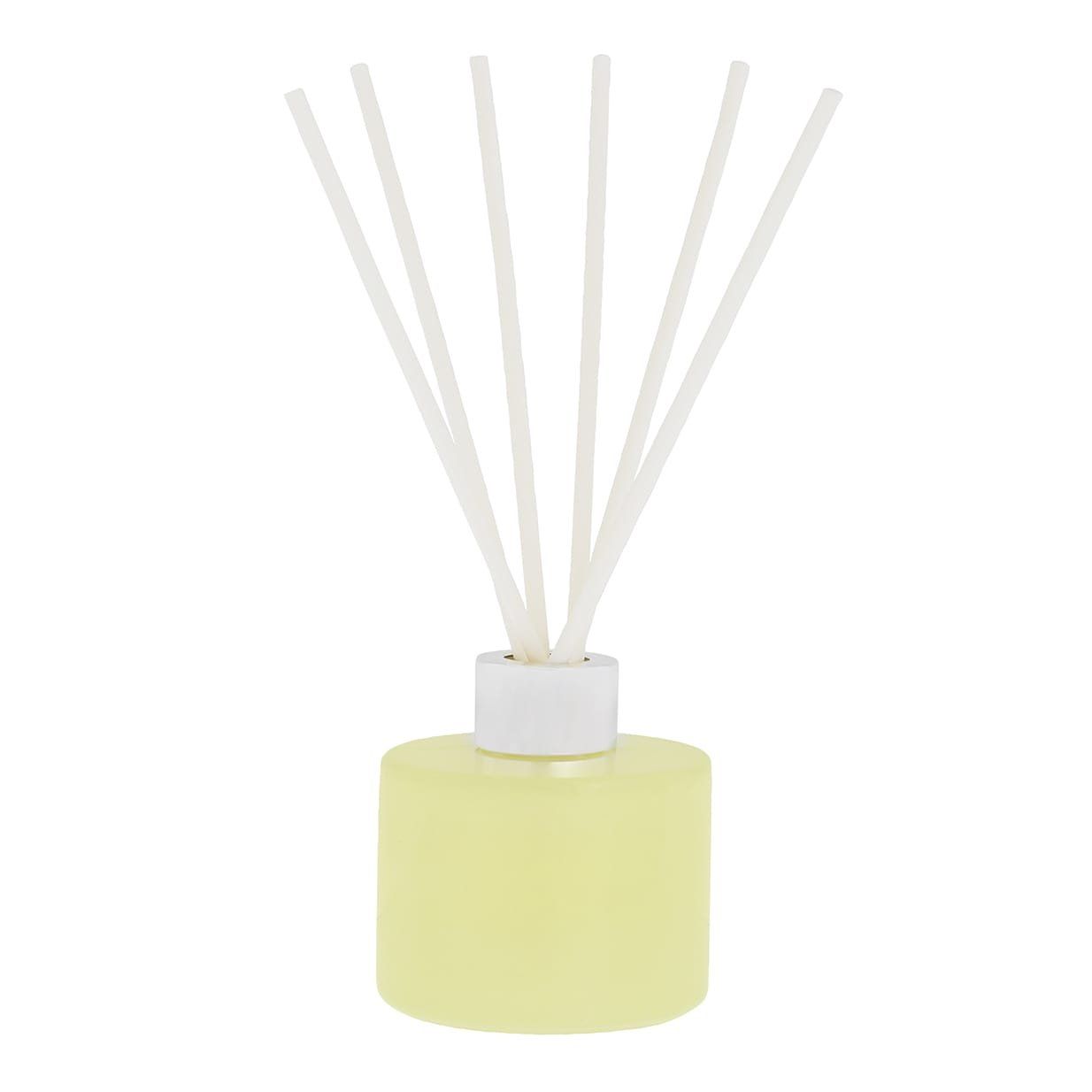 Gele diffuser met witte rietjes; op het etiket staat