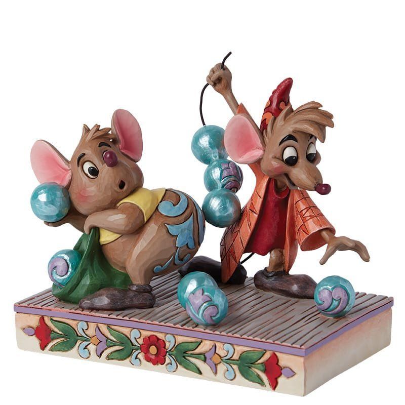 Twee Disney-muisjes met blauwe bollen op een decoratief platform. De ene houdt een groene tas vast, de andere jongleert.