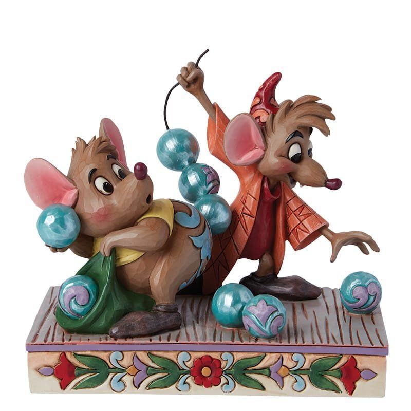 Twee Disney-muizen, Jaq en Gus, met blauwe kralen, op een platform. Jaq houdt een tas vast. Gus houdt een touwtje vast.