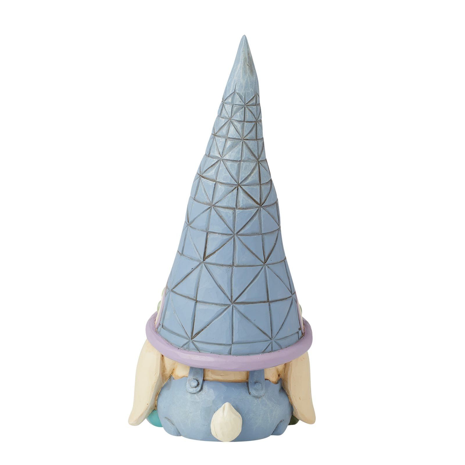 Een blauw konijnenkabouterfiguurtje met een hoge, bedrukte hoed op, dat van zich afgekeerd staat.