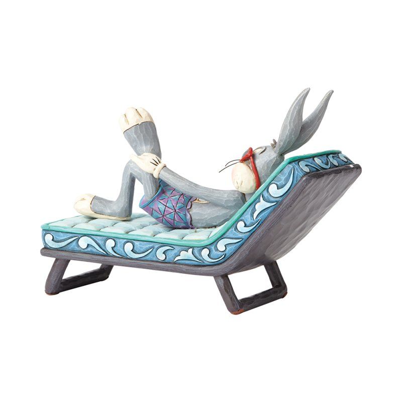 Bugs Bunny, met zonnebril op, zit ontspannen in een blauwe ligstoel te lezen.