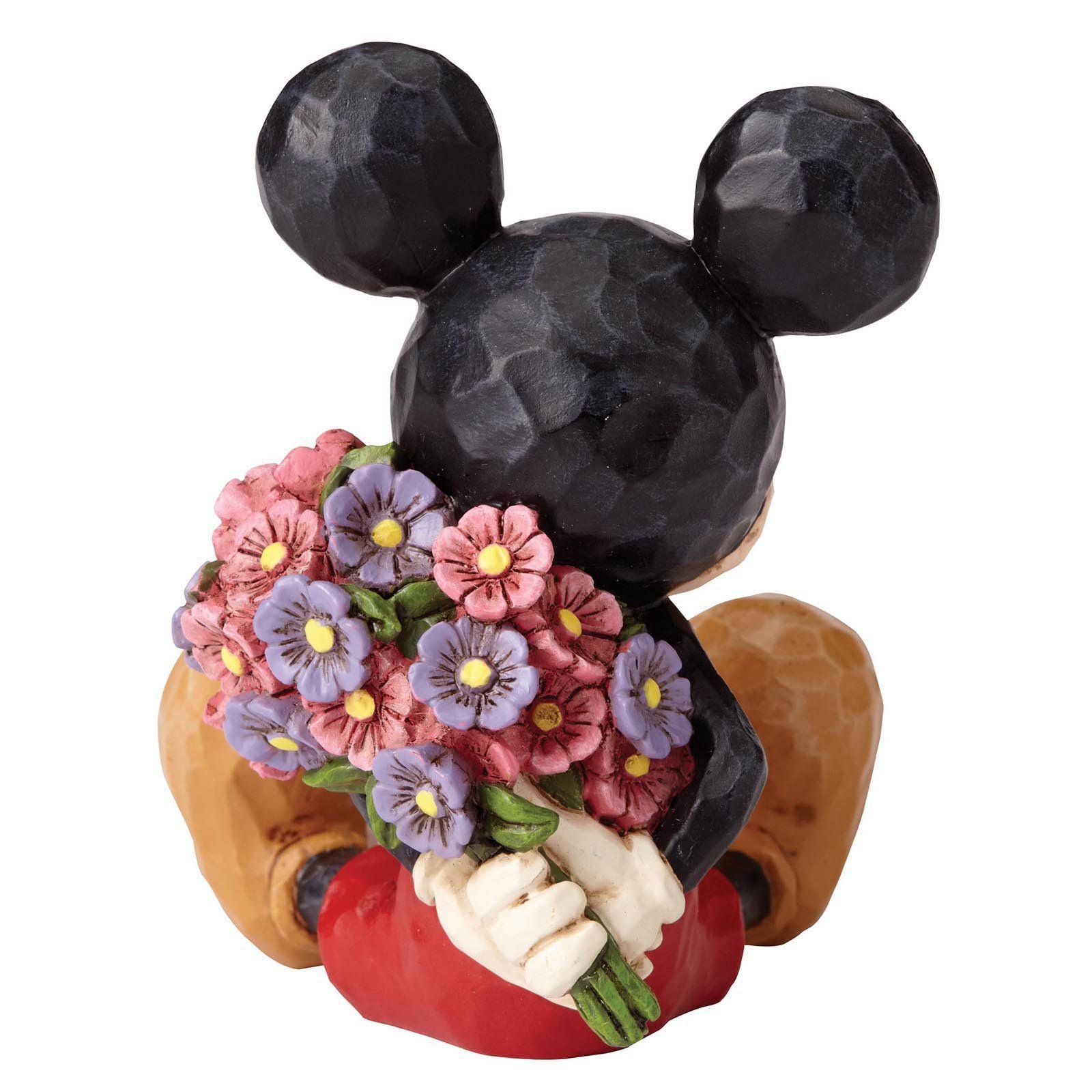 Mickey Mouse-figuurtje met bloemen, zittend, rode korte broek, bloemen vasthoudend, oren en schoenen met patroon.