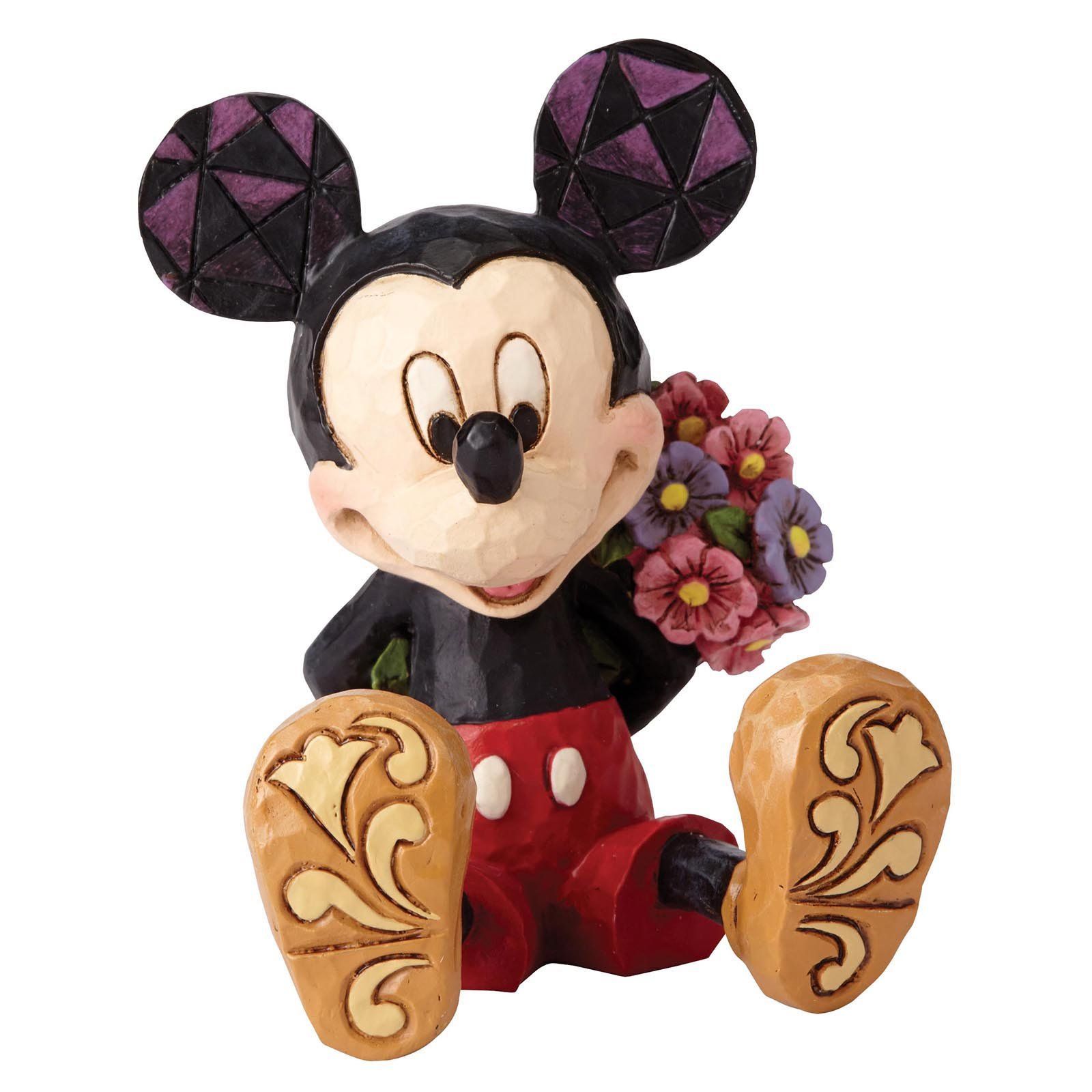 Mickey Mouse-figuurtje met bloemen, zittend, rode korte broek, bloemen vasthoudend, oren en schoenen met patroon.