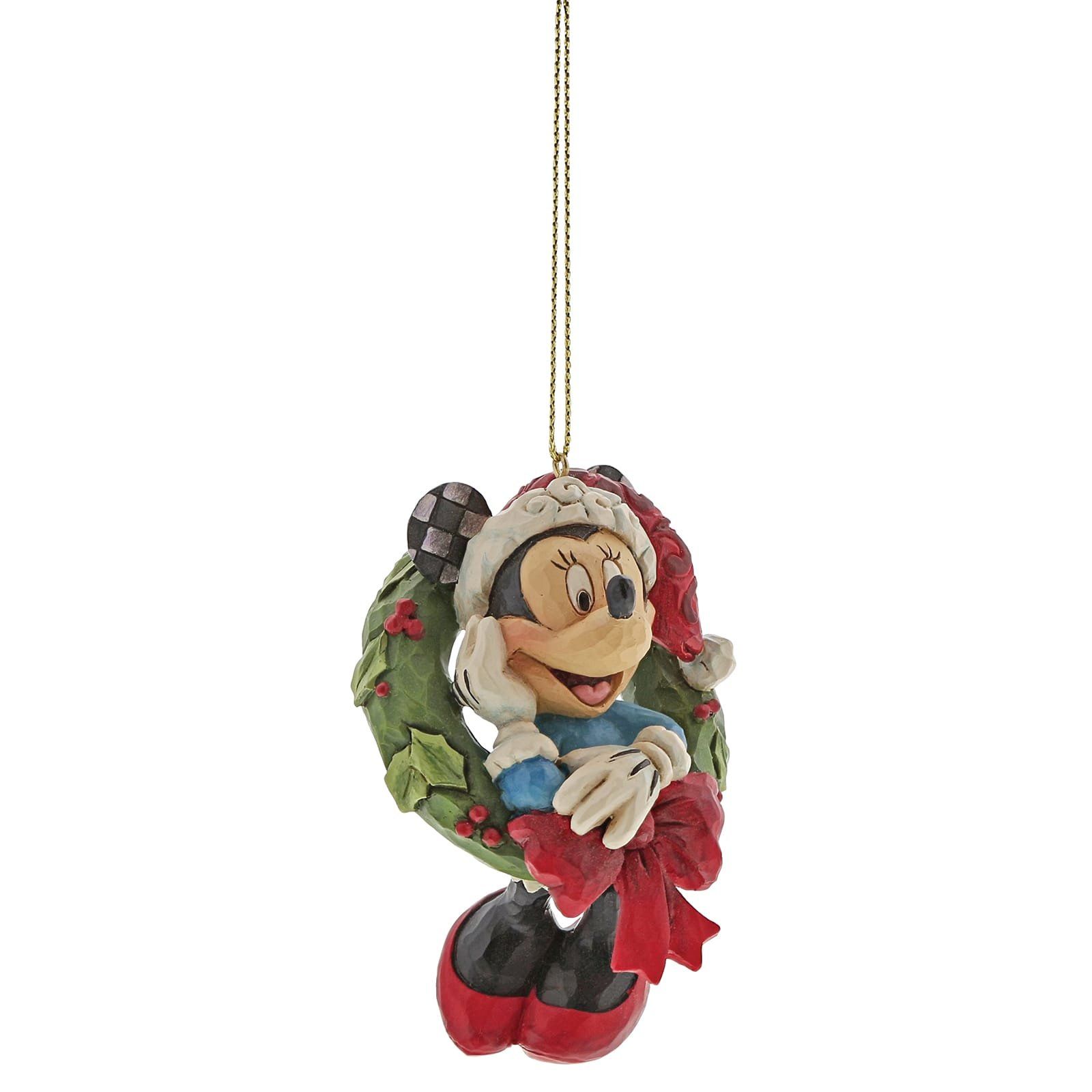 Een kerstornament van Minnie Mouse in een krans. Ze draagt een muts, wanten en een strik.