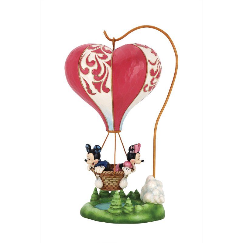 Mickey en Minnie Mouse in een hartvormige heteluchtballon, boven een groen landschap met bomen.