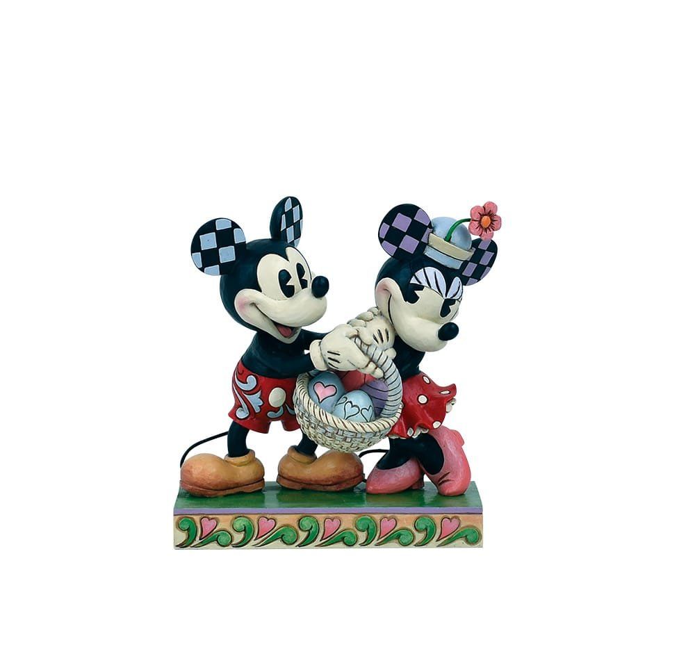 Een beeldje van Mickey en Minnie Mouse met een mandje paaseieren, staand op een versierde sokkel.