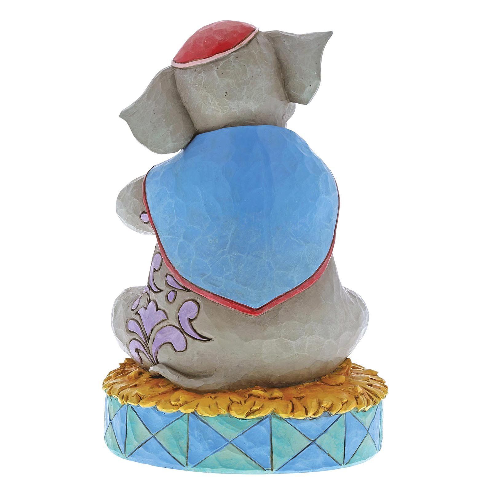 Een Dumbo-figuurtje dat een babyolifantje vasthoudt, beiden op een circuspodium.