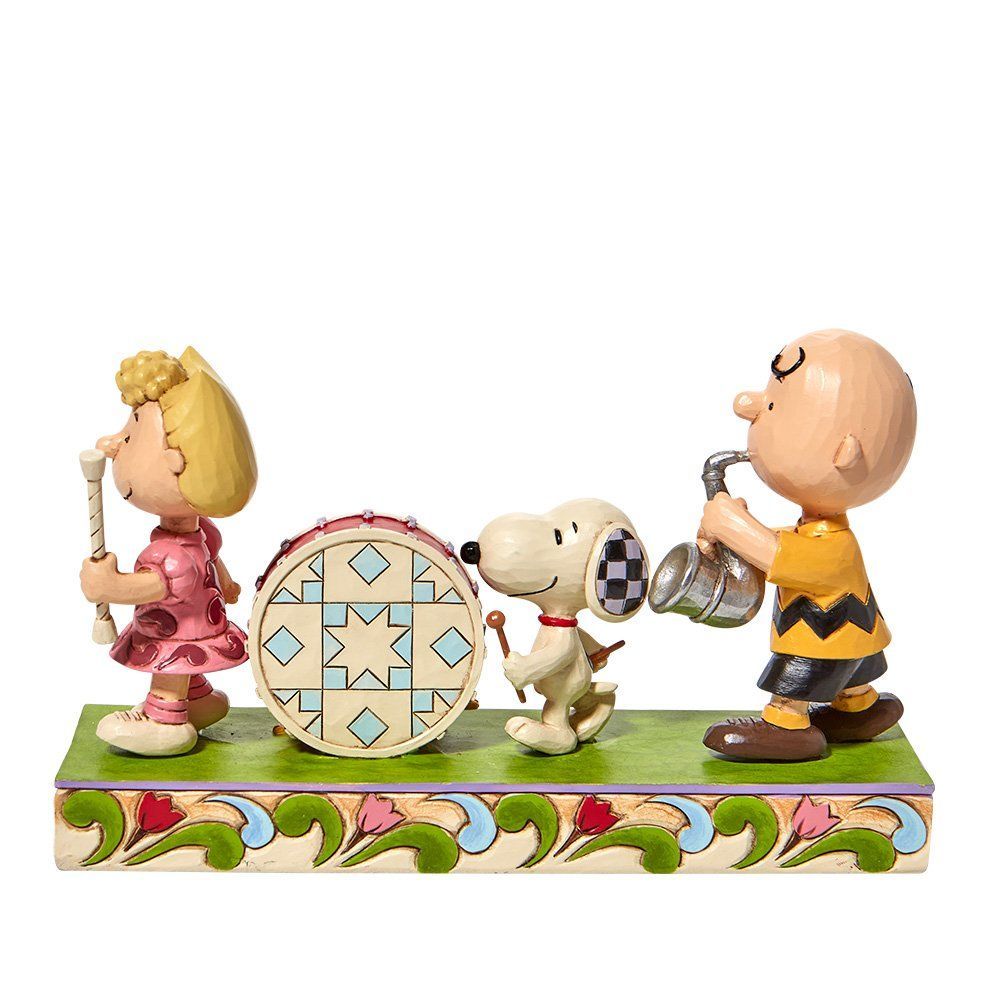De Peanuts-personages die muziek maken: Charlie Brown, Snoopy, een drumstel en Marcie.