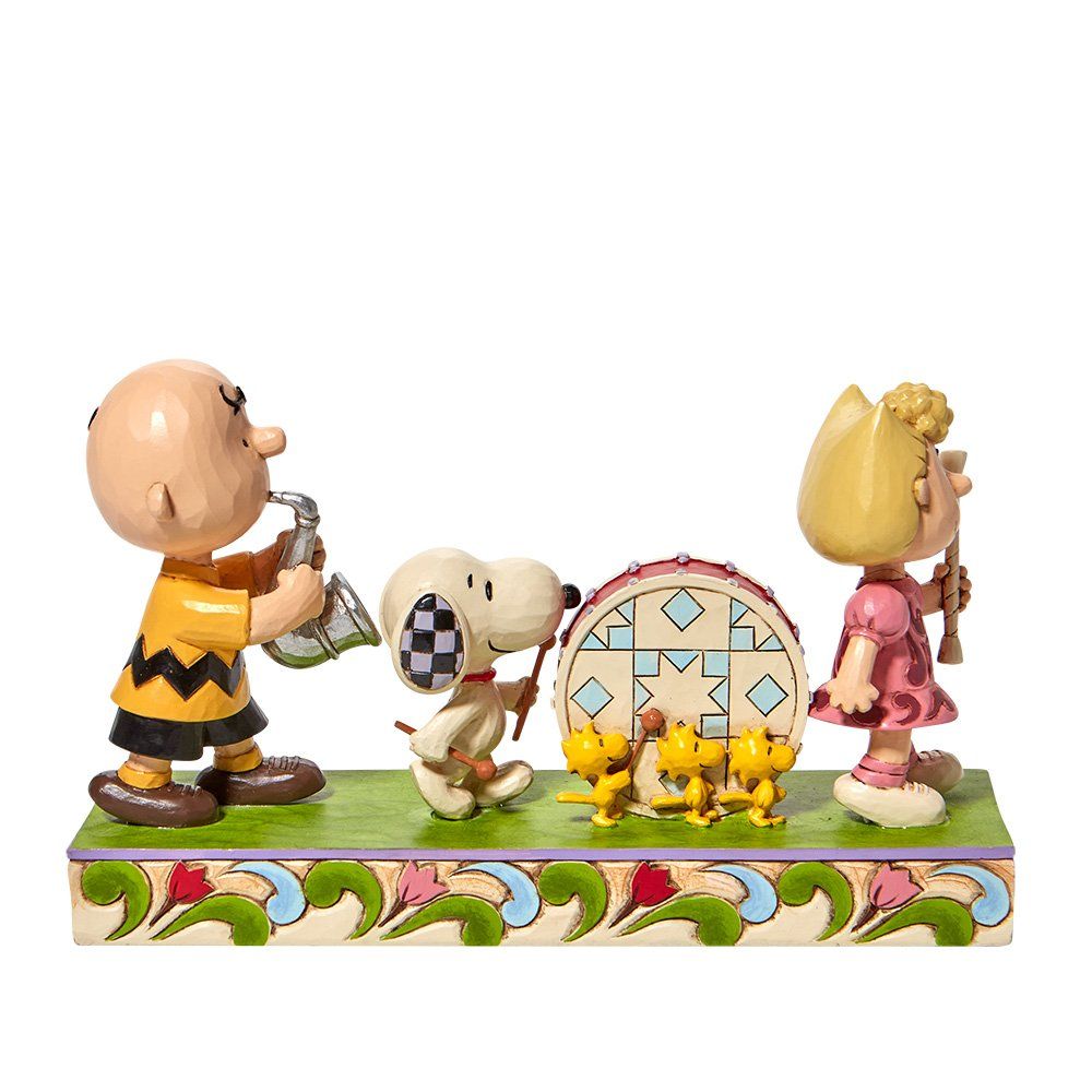 De Peanuts-personages die muziek maken: Charlie Brown, Snoopy, een drumstel en Marcie.