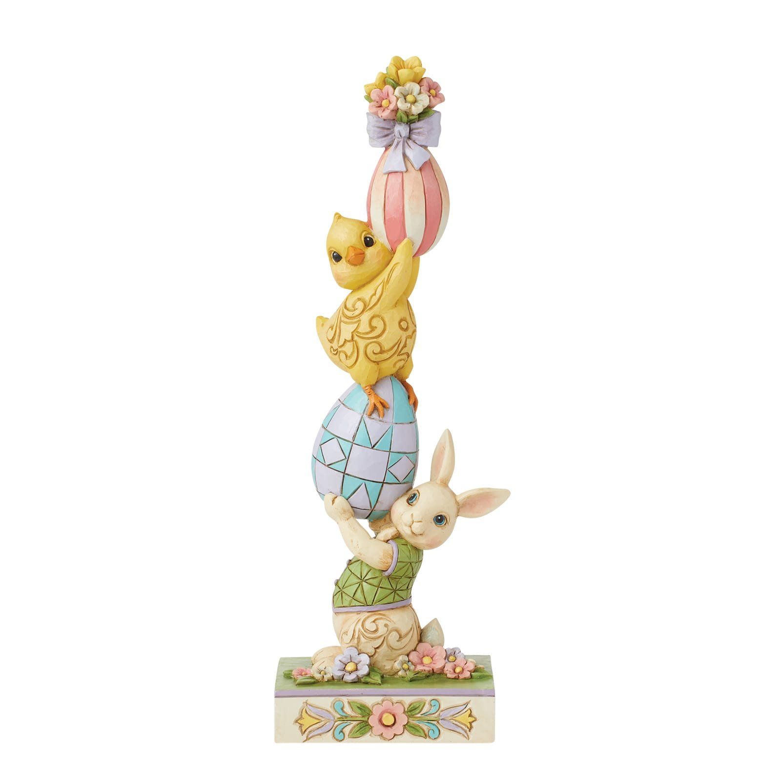 Paasfiguurtje: konijntje, kuikentje en twee gestapelde eieren. Pastelkleuren. Bloemen op de voet en het bovenste ei.