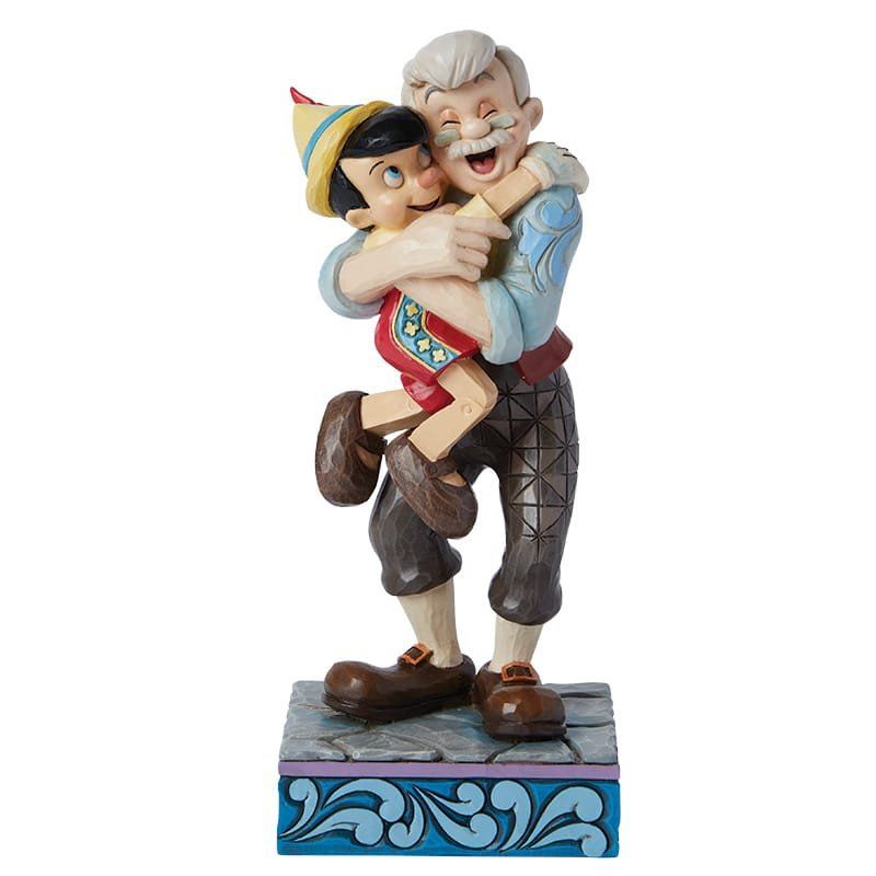 Pinocchio en Geppetto omhelzen elkaar en glimlachen; kleurrijk beeld op een decoratieve sokkel.