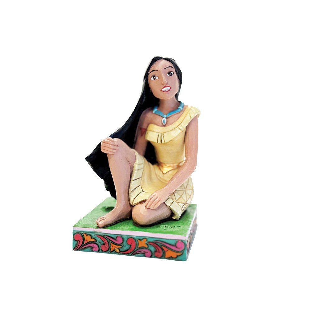 Een beeldje van Pocahontas op een decoratieve sokkel, gekleed in een gele jurk en met een blauwe halsketting, kijkt omhoog.