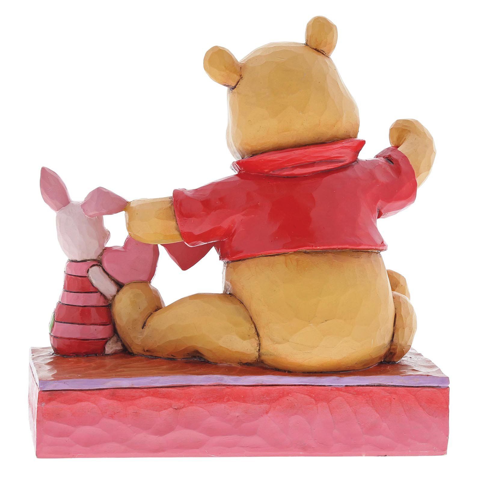 Winnie de Poeh en Knorretje houden hartjes vast, van achteren gezien, op een rode en roze ondergrond.