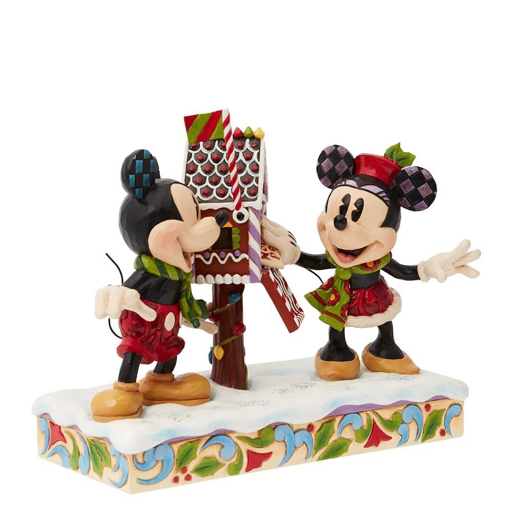 Mickey en Minnie Mouse versieren een peperkoek brievenbus in de winter, met een lachend gezicht; een kleurrijk ornament.