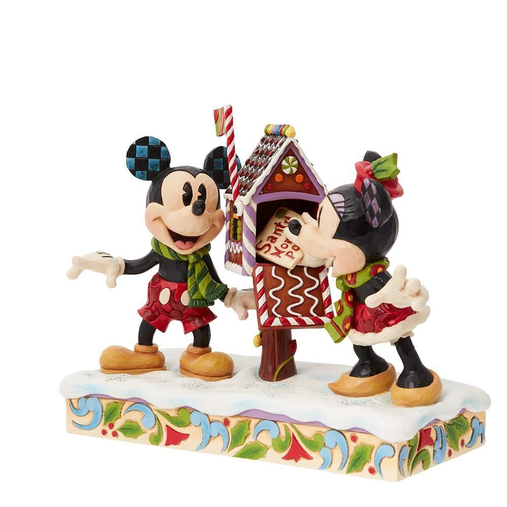 Een kerstfiguurtje van Mickey Mouse en Minnie Mouse die elkaar kussen bij een peperkoek brievenbus.
