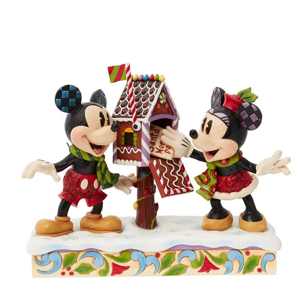Mickey en Minnie Mouse-figuurtjes versieren een peperkoekhuisje met sneeuw en feestelijke details.
