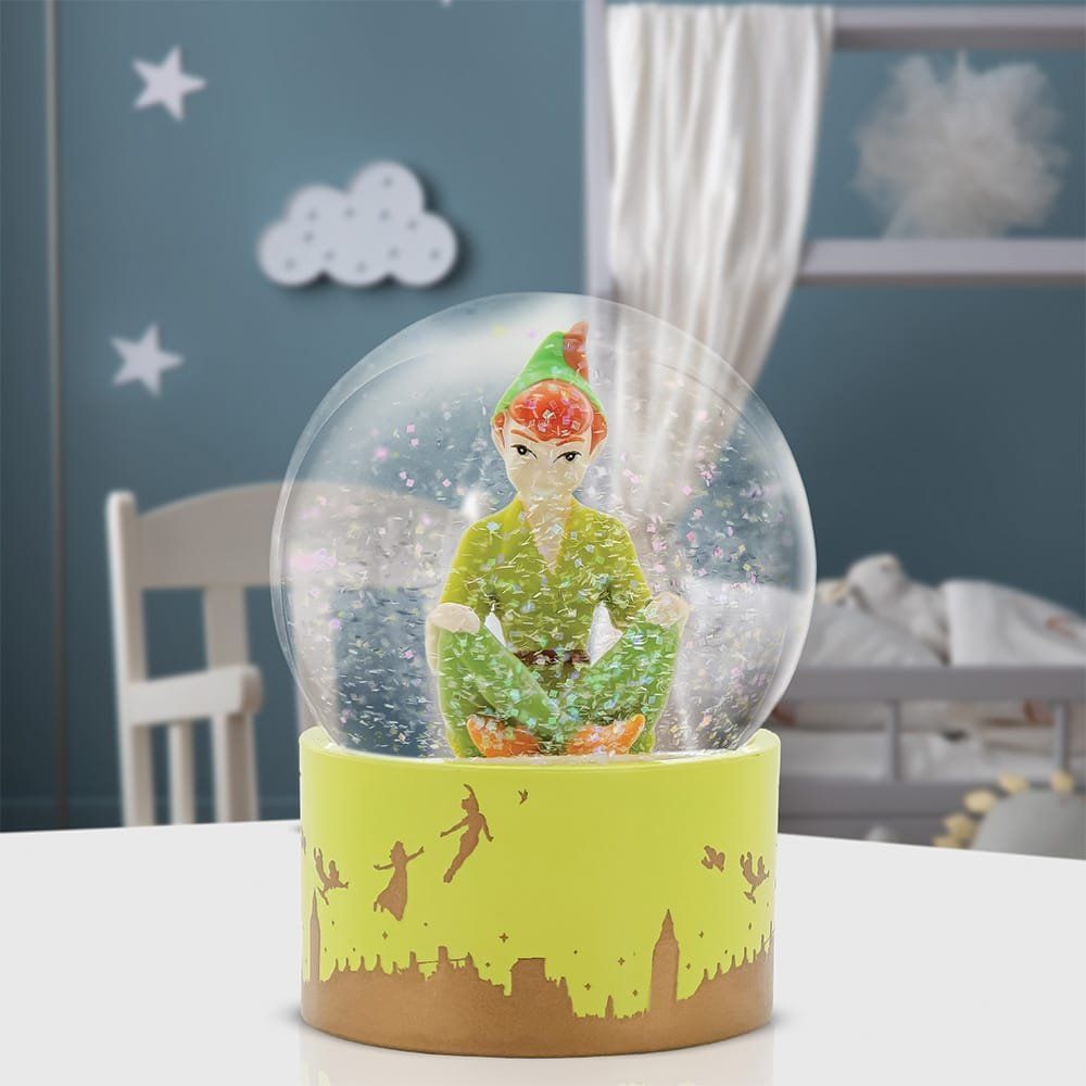 Sneeuwbol met Peter Pan-figuur, groene figuur, gele voet met silhouet van een stadsgezicht, witte glitter aan de binnenkant.