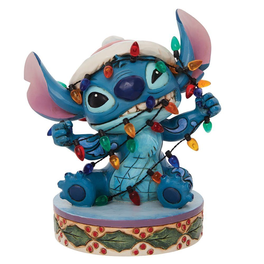 Een Stitch-figuurtje verstrikt in kerstverlichting, met een kerstmuts op.