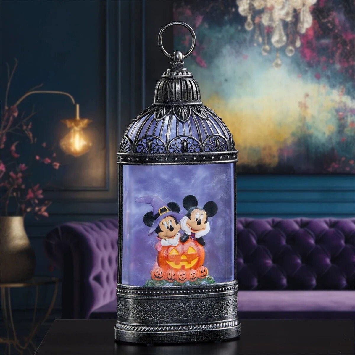 Een Halloweenlantaarn met Mickey en Minnie Mouse en een paarse gloed, op een tafel voor een paarse bank.