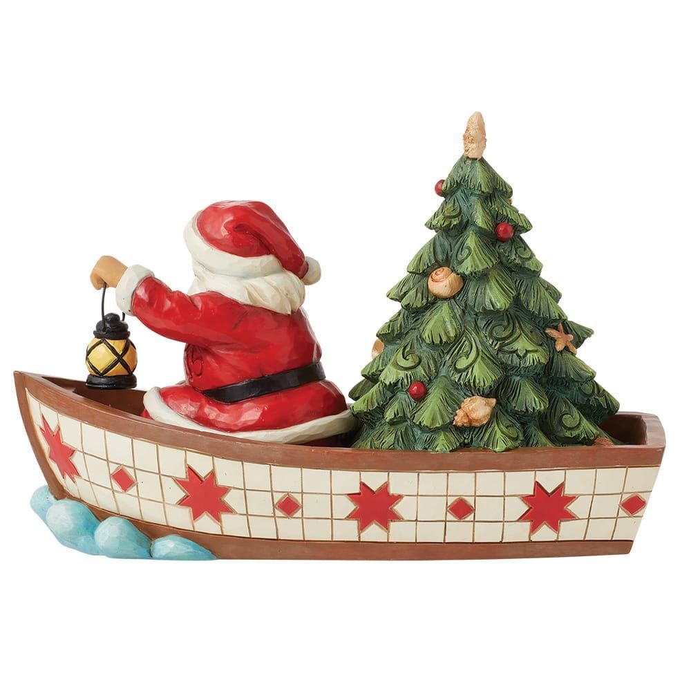 De Kerstman in een boot met een kerstboom. De Kerstman houdt een lantaarn vast. De boot is versierd met sterren.